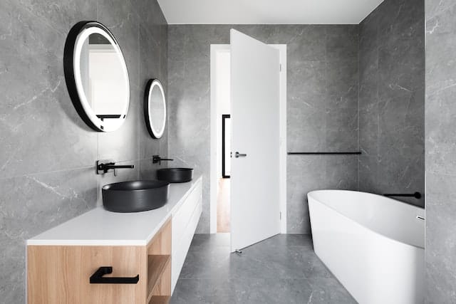 mirror above white ceramic bathroom sink