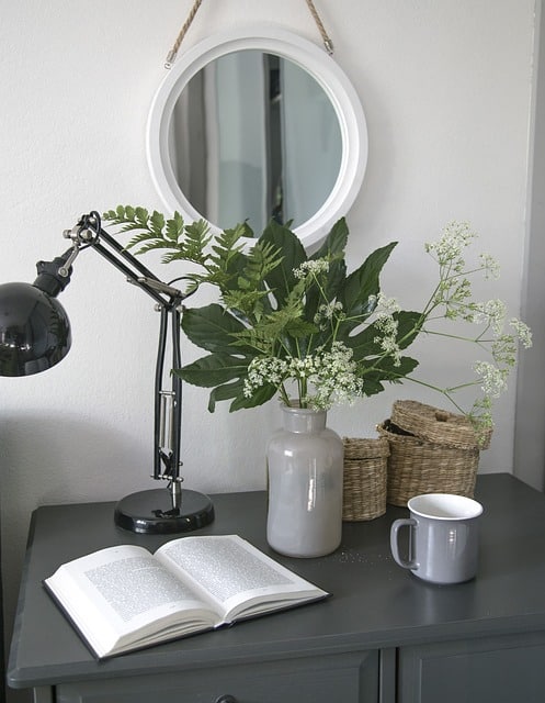 mirror on wall and flower vase on table